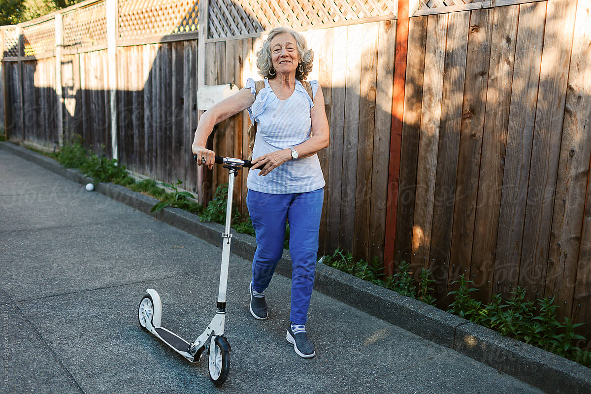 Senior woman with scooter by neighborhood