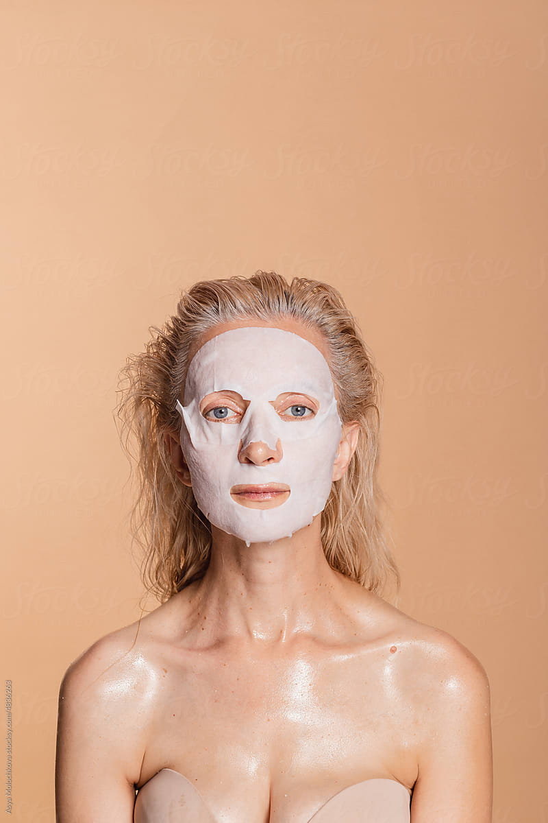 Relaxed portrait of beautiful woman with sheet mask on face