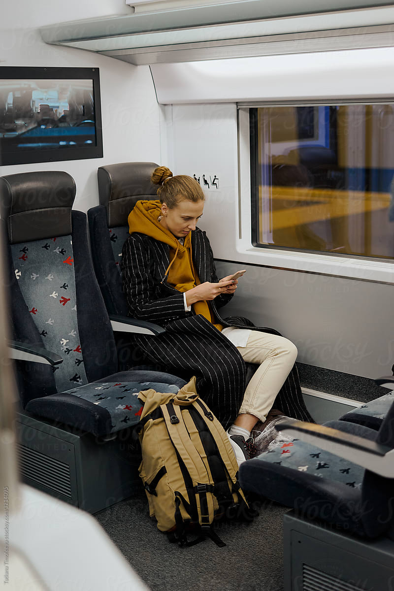 woman using smartphone in train to airport