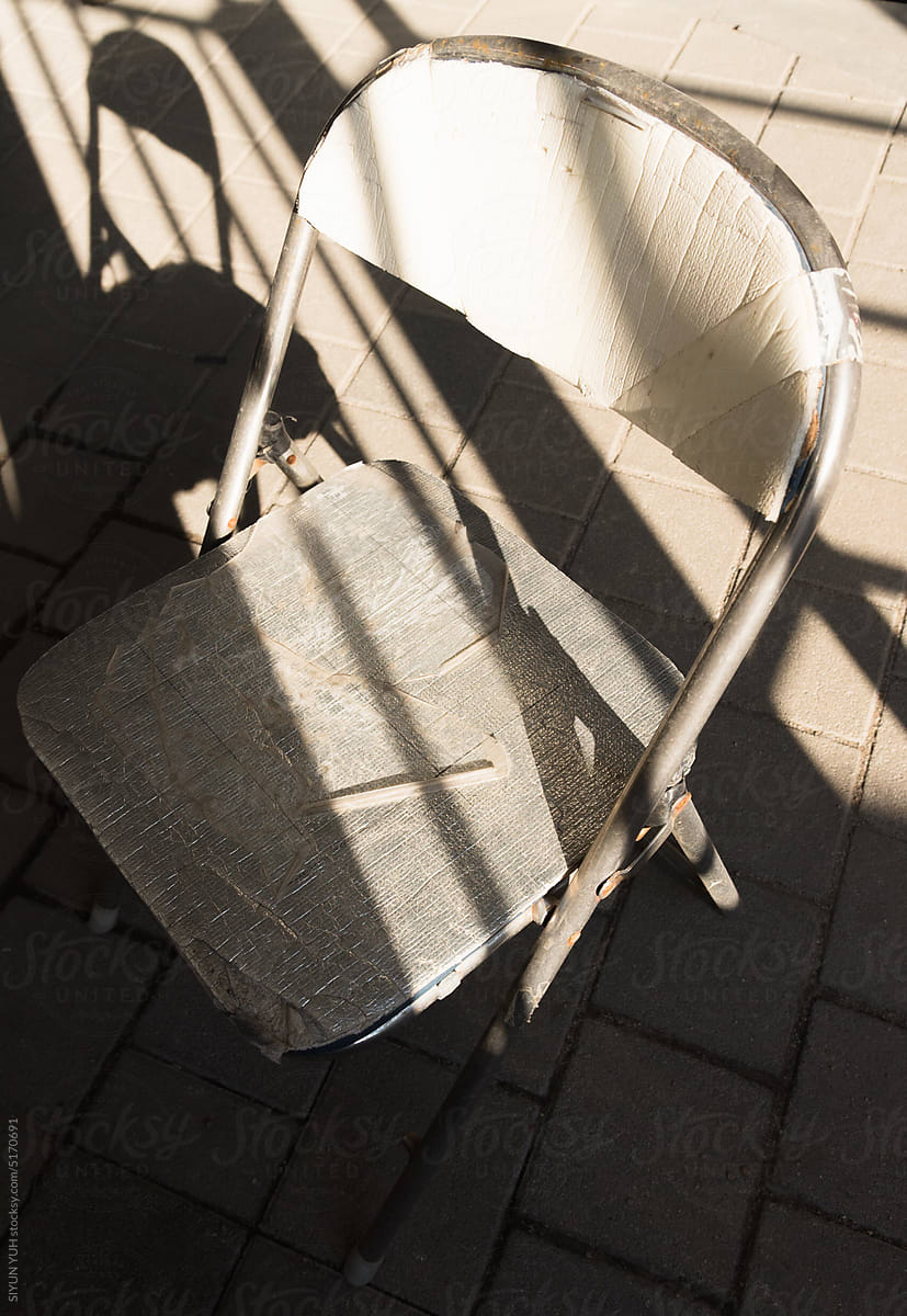 White chair with its shadow on the street