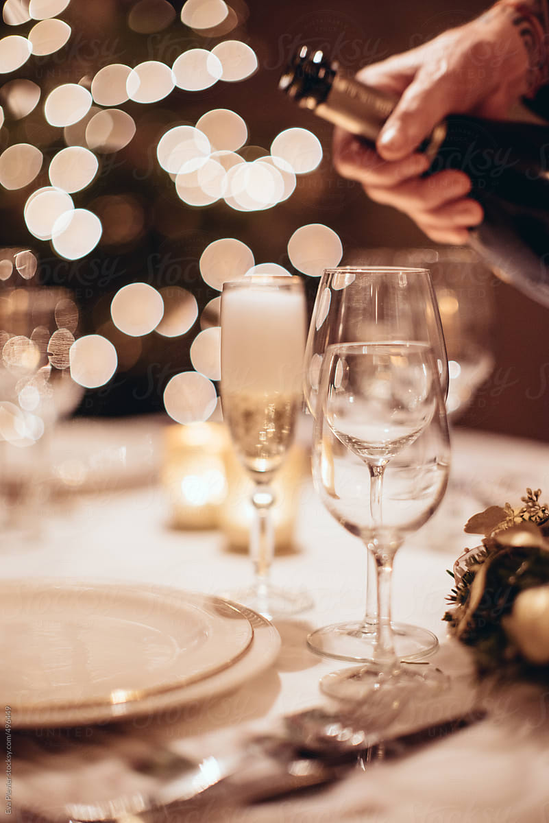 Serving champagne in a cozy christmas dinner with family and friends.