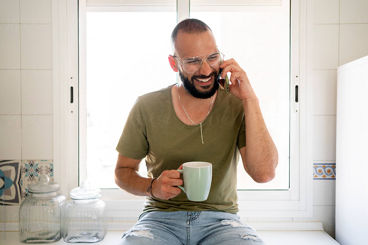 Man smiling calling by phone at kitchen