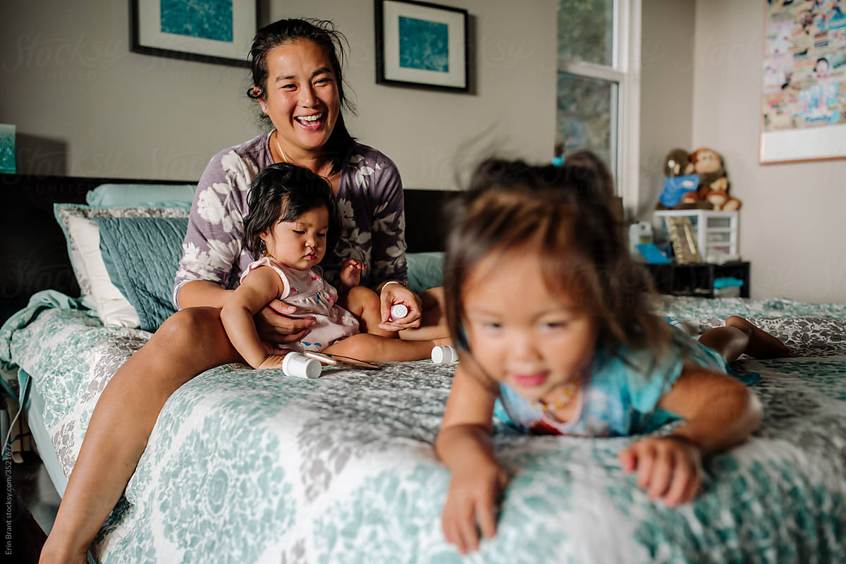 Smiling Asian ther caring for daughters