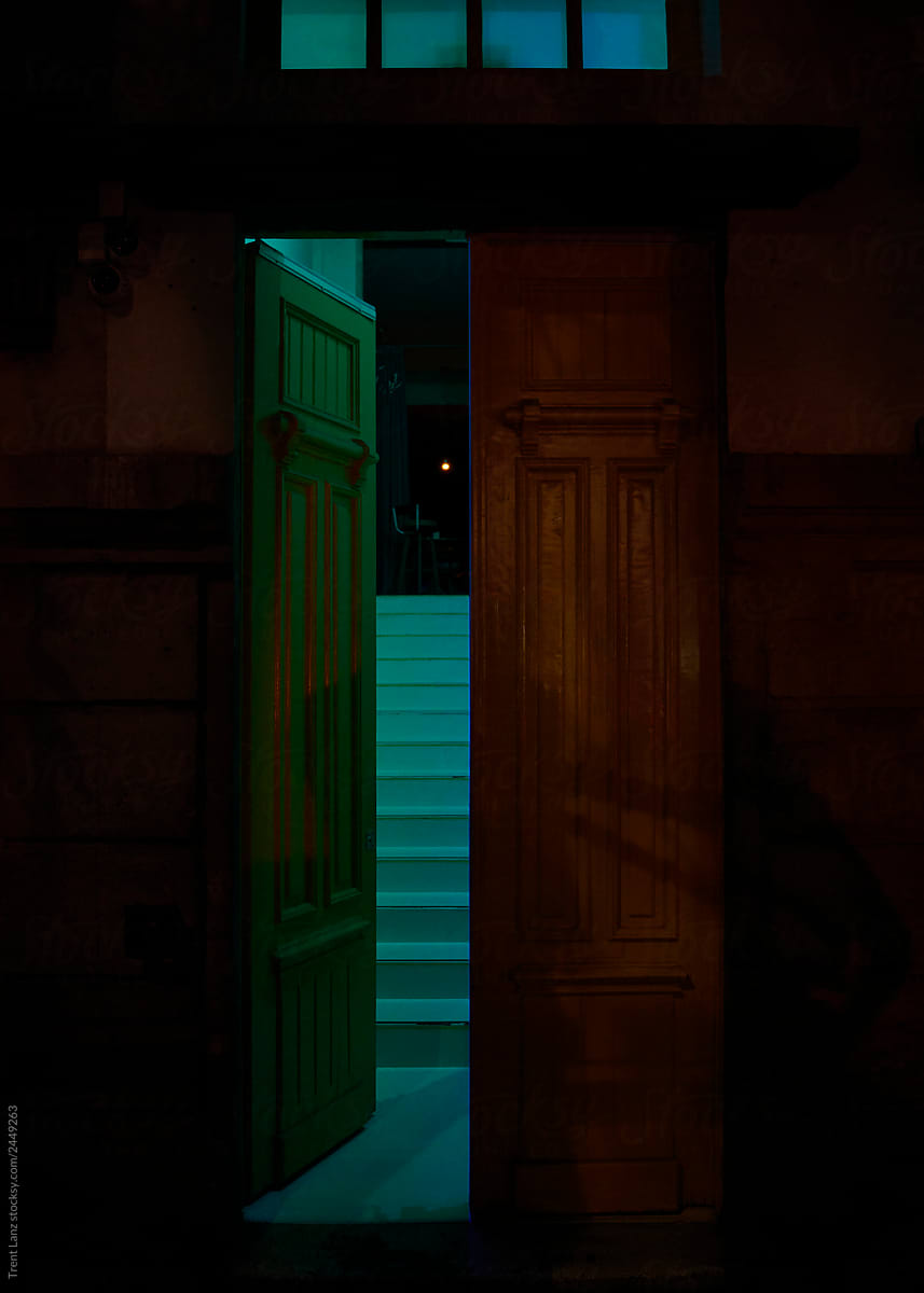 Open wood doorway to colorful blue lit stair entryway
