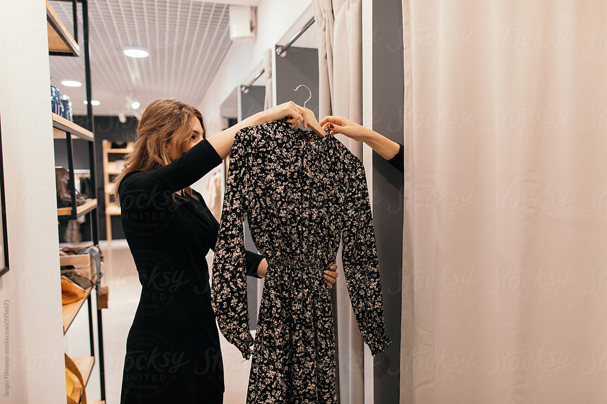 Shop assistant helping customer in fitting room