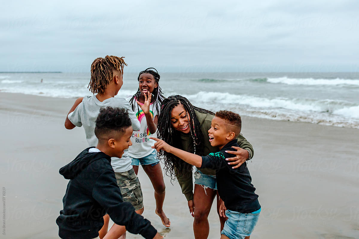 Happy Black family huddled at beach