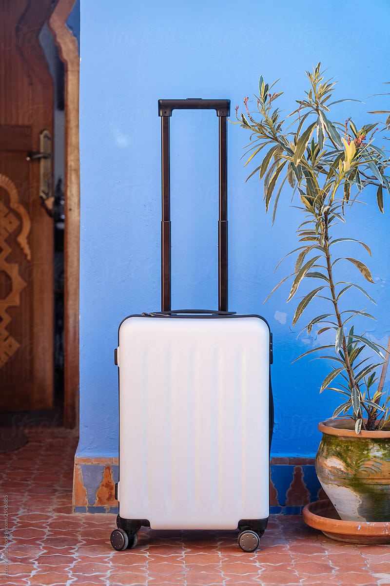 White suitcase by blue wall