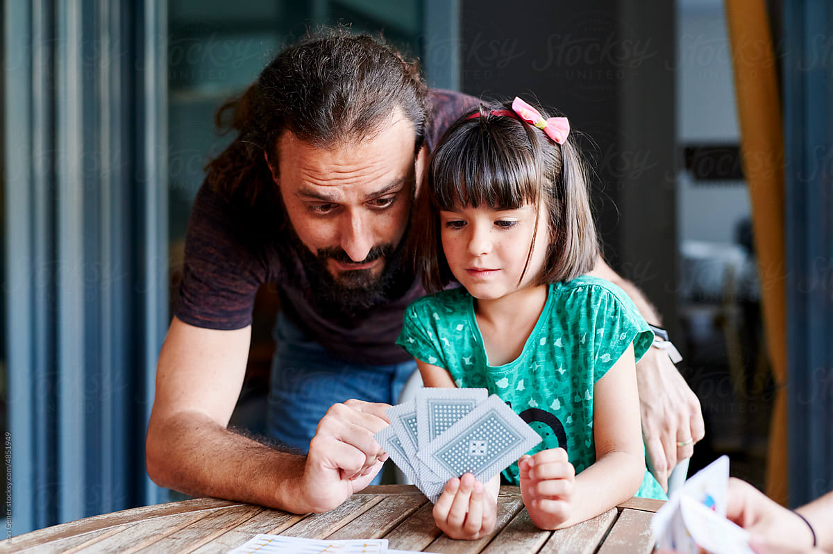 Dad teaching his daughter cards outside