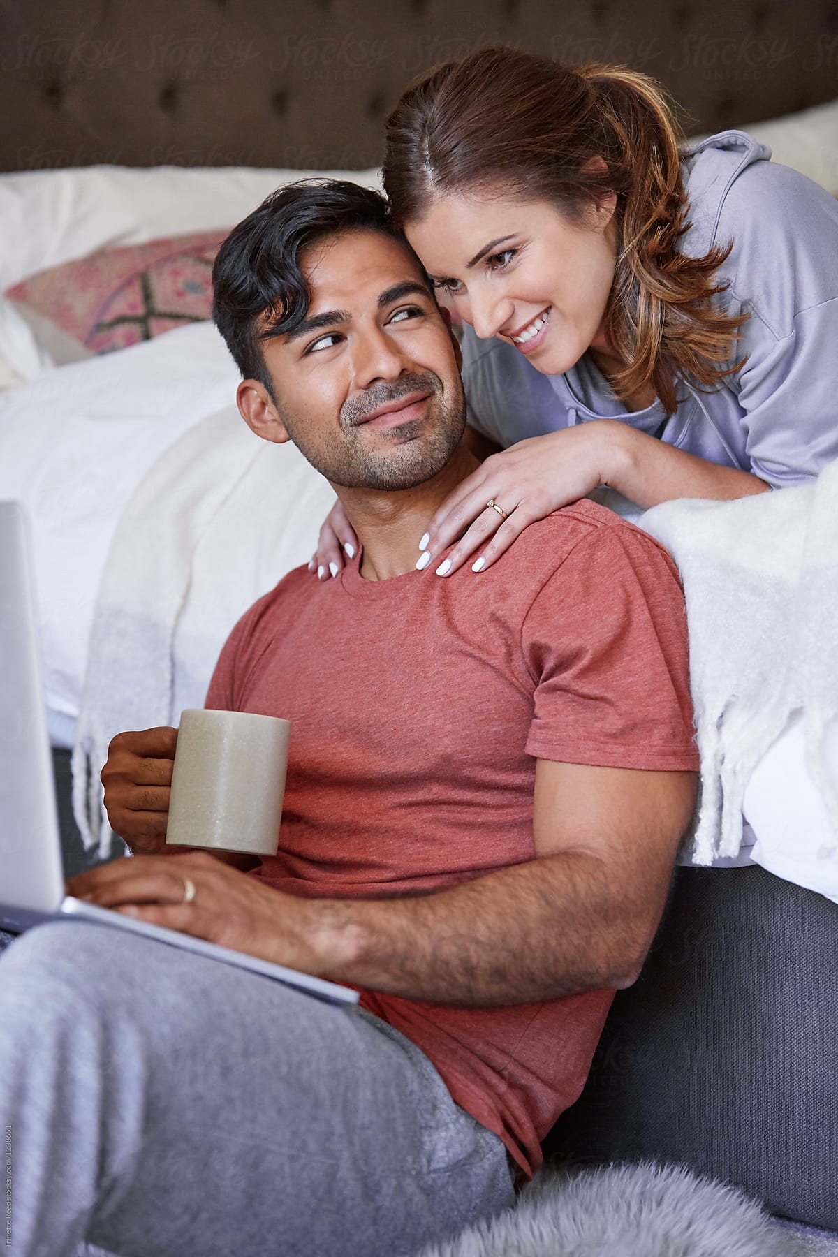 Young Multiethnic Couple Relaxing In Their Bedroom In The Morning With