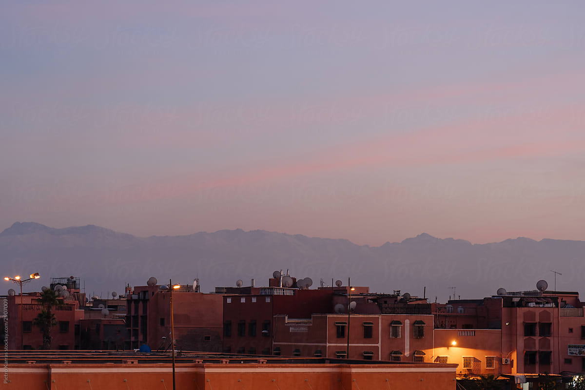 Modern Arabic city beside mountain chain on sunset