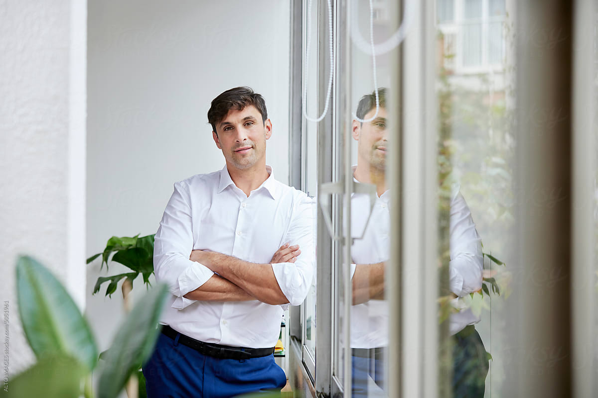 Positive formal male standing near window