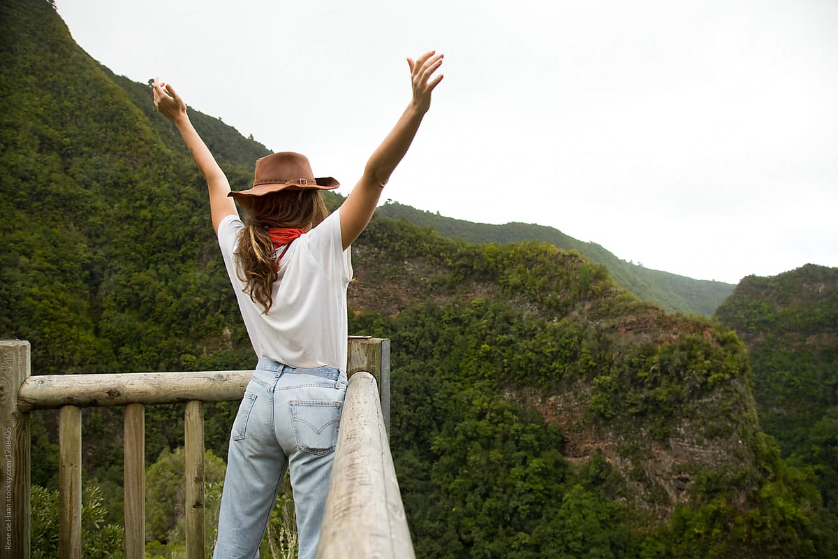 young woman at viewpoint overlooking mountain forest