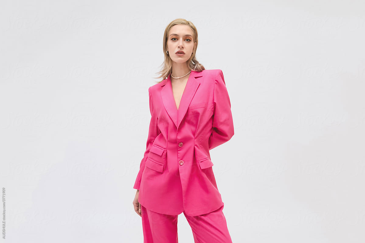 Blond stylish female in pink suit .