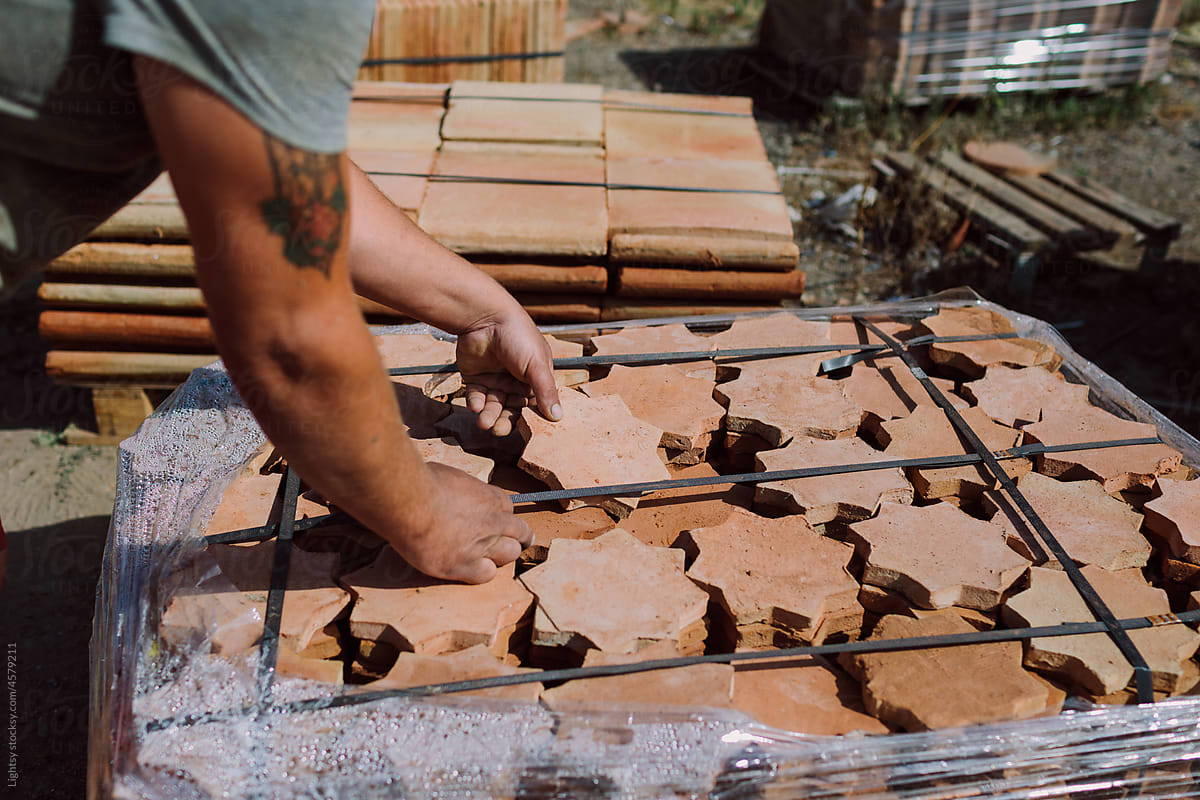 Man placing finished tiles in pallets