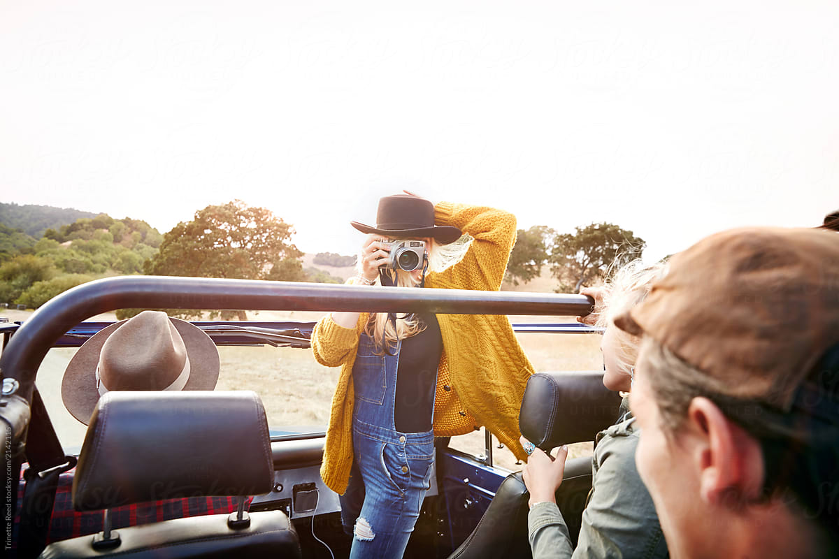 Woman taking a photo with vintage film camera on road trip