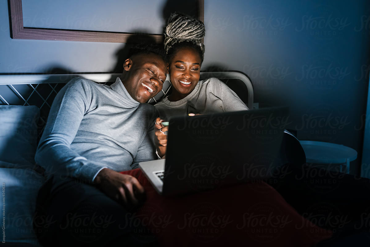 Happy African American couple laughing at comedy