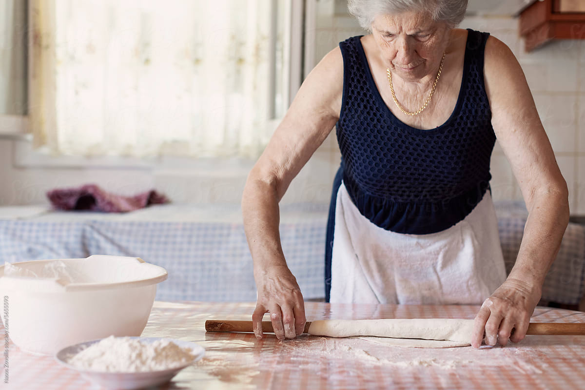 Senior woman preparing a greek traditional food in her kitchen