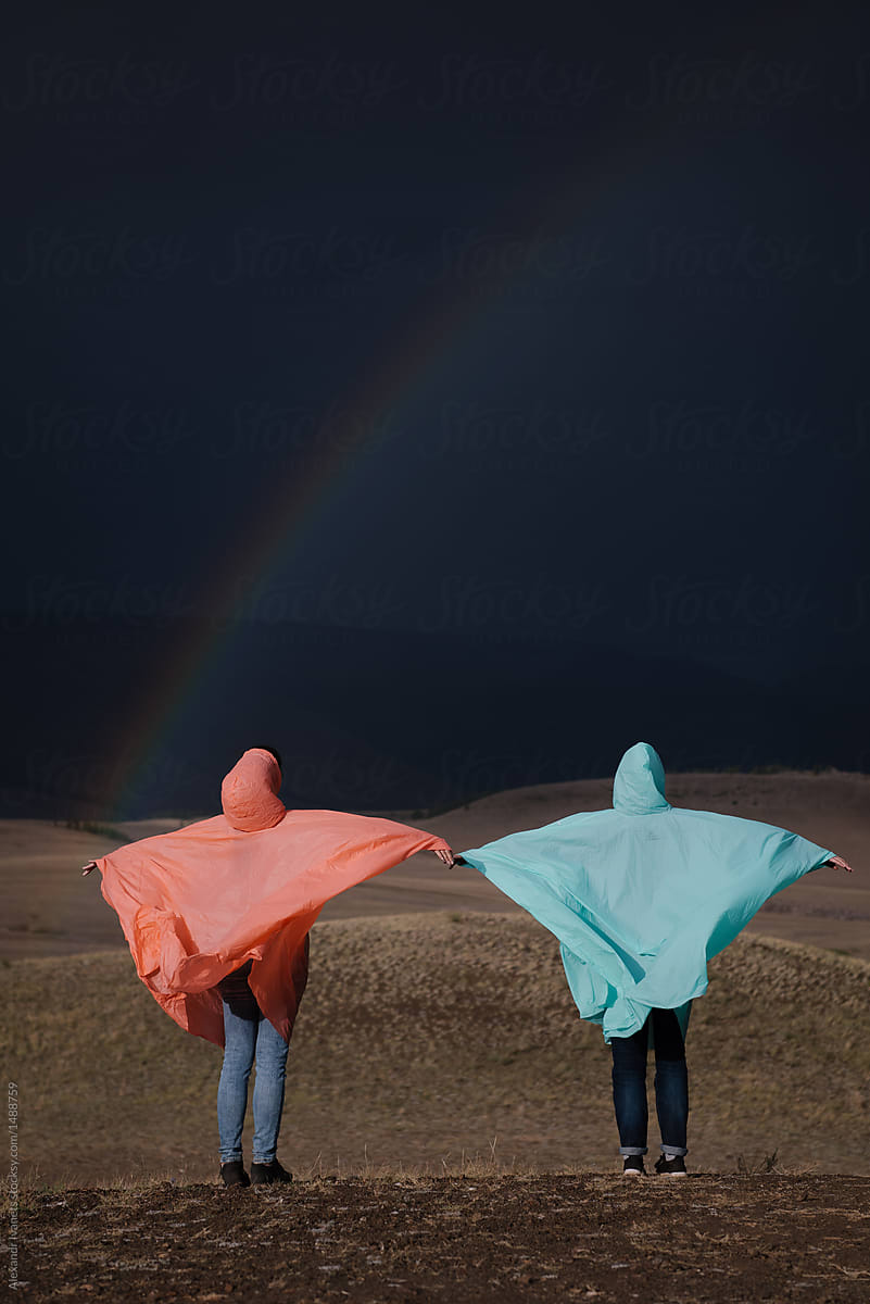 Two people posing in raincoats