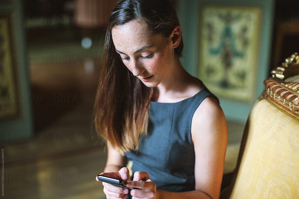 Young businesswoman using smart phone at beautiful baroque room.