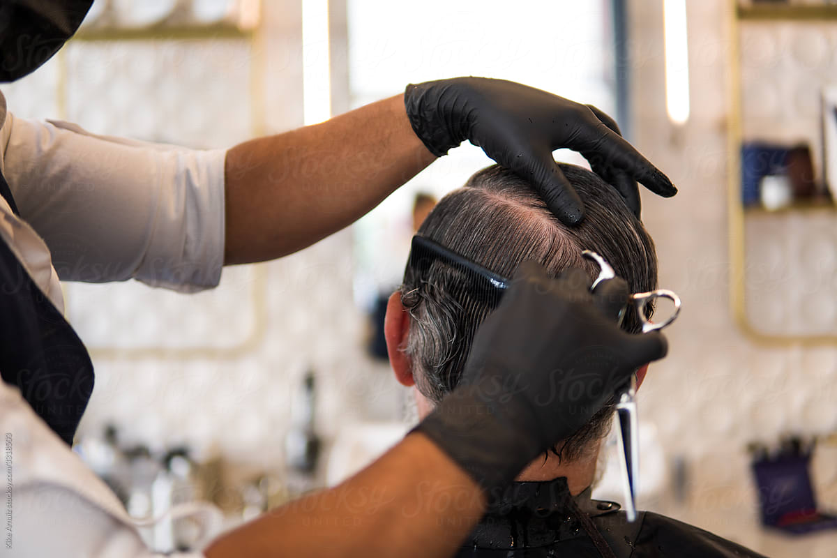 Hairstylist cutting man's hair