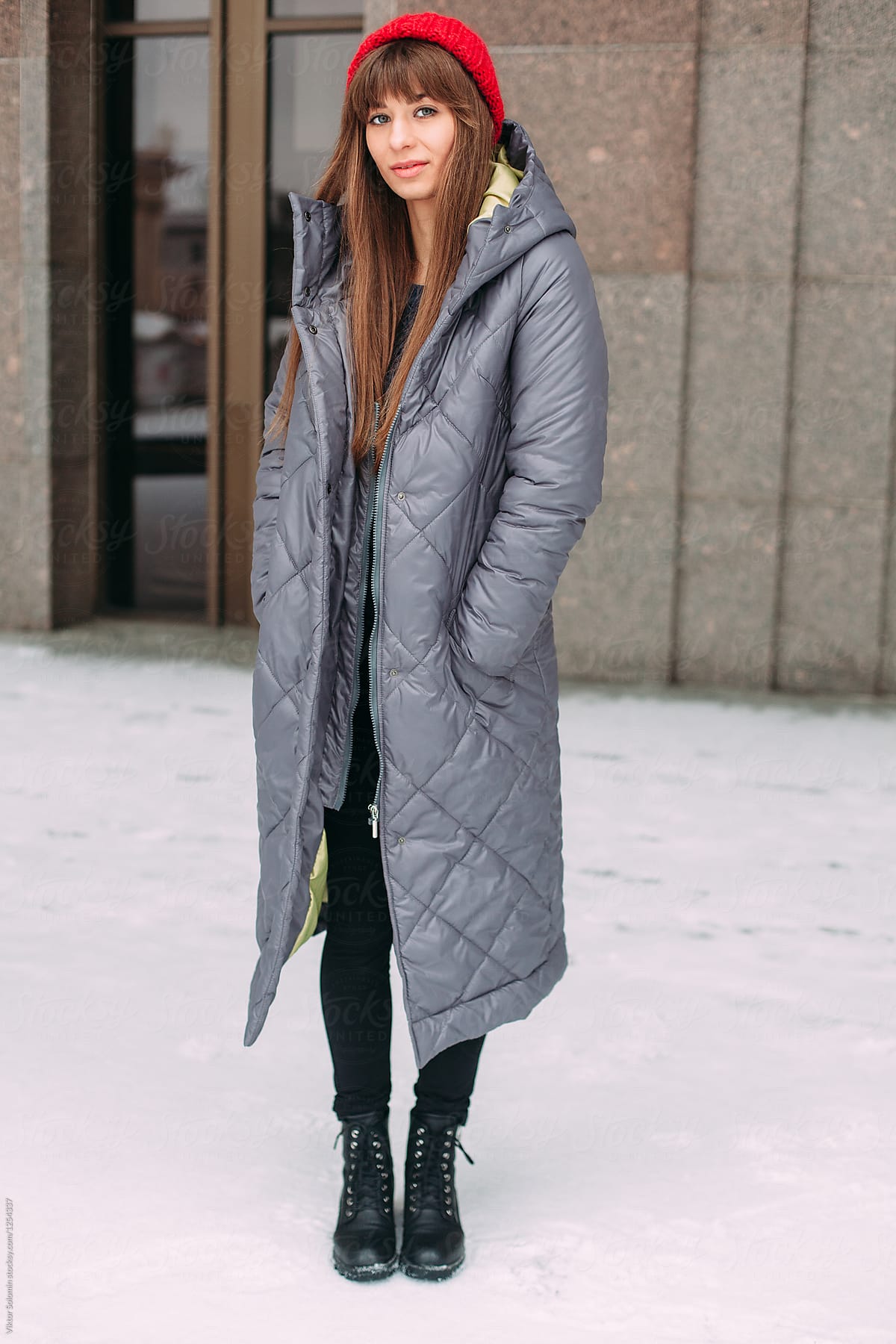 Happy young woman posing outdoor on the street in winter in winter coat
