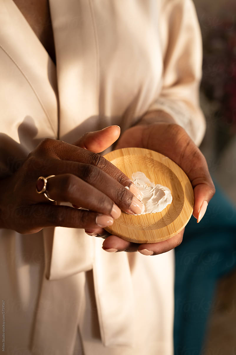Closeup of woman taking Kaolin Clay to fingers