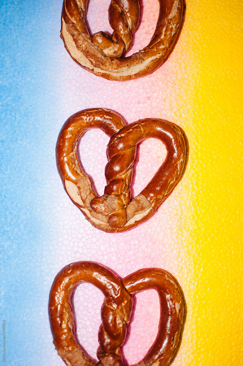 Heart-shaped pretzels on rainbow background