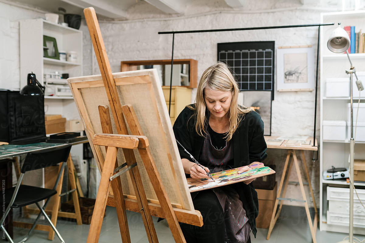Woman with palette painting in craft studio