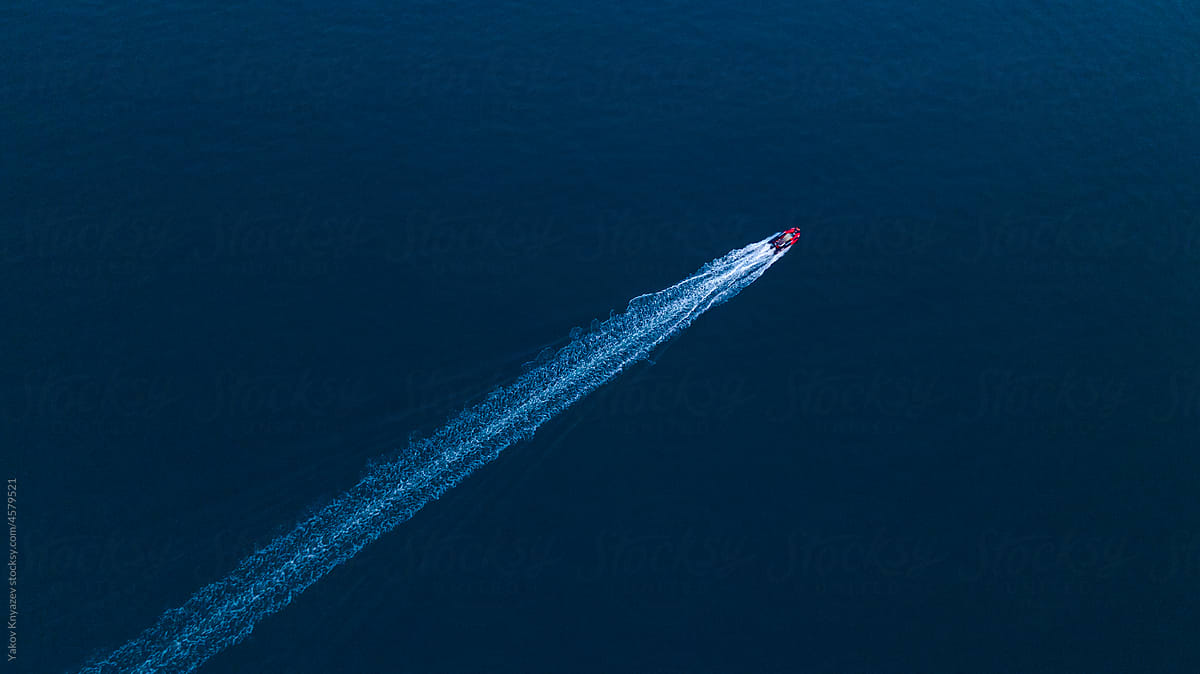 drone view of a motorboat racing fast in the dusk