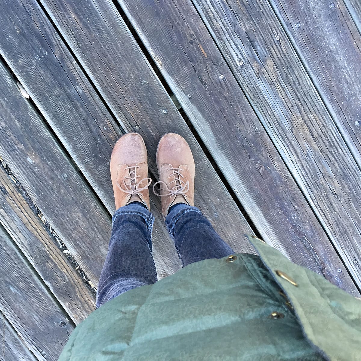 A Woman\'s Feet Standing On A Wood Deck On An Autumn Day