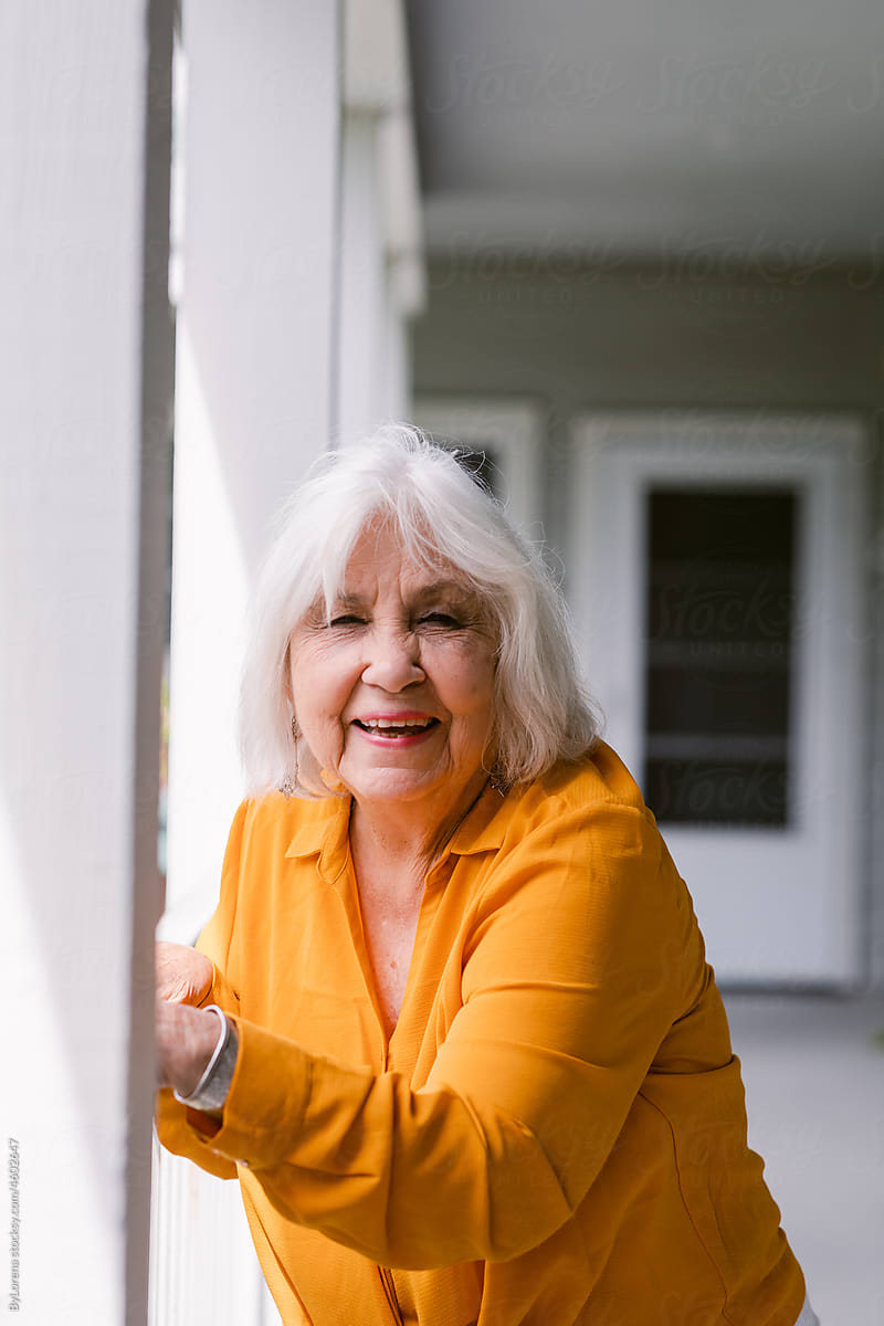 White hair woman in yellow at residence portrait