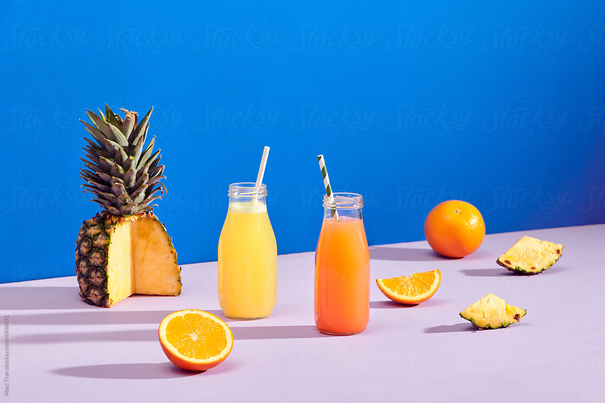 two tasty healthy orange drink fruits juice bottles on color