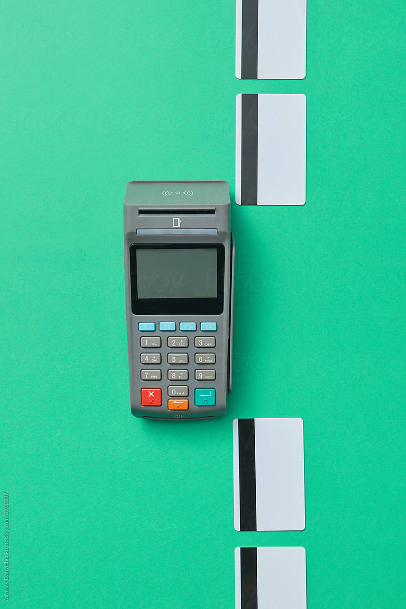 POS terminal and credit cards on green background