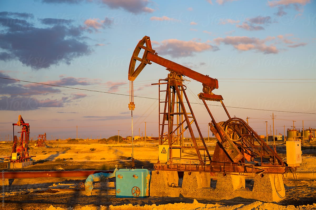 Oil Industry: Pumpjack on the oilfield at sunset