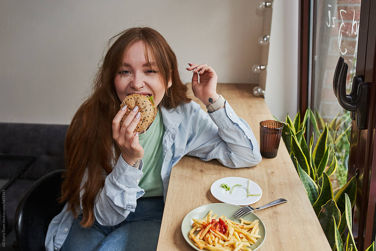 Young woman eating hamburger