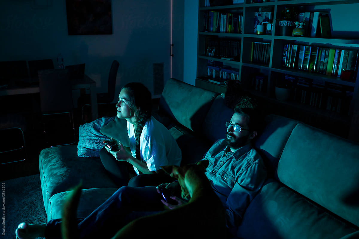 Excited happy couple playing videogames at night