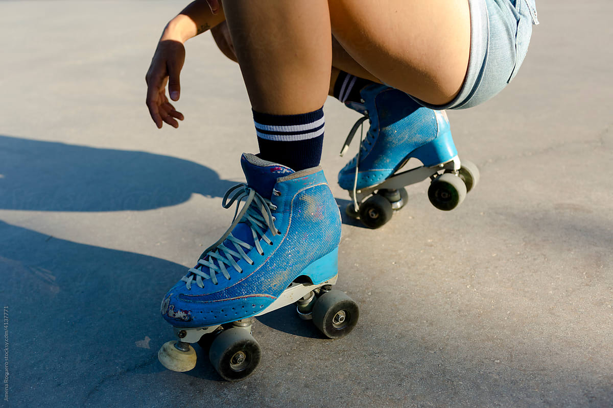 Detail of roller skater legs squatting on skate park