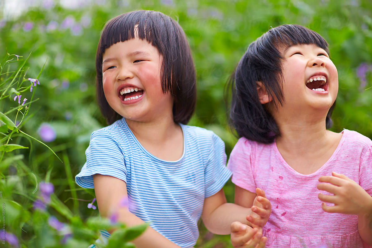 two happy little girls laughing outdoor