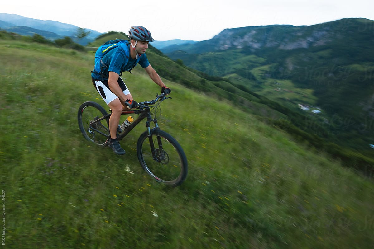 Cyclist Man Riding Down A Steep Hill During Sunset By Stocksy Contributor Ibex Media Stocksy