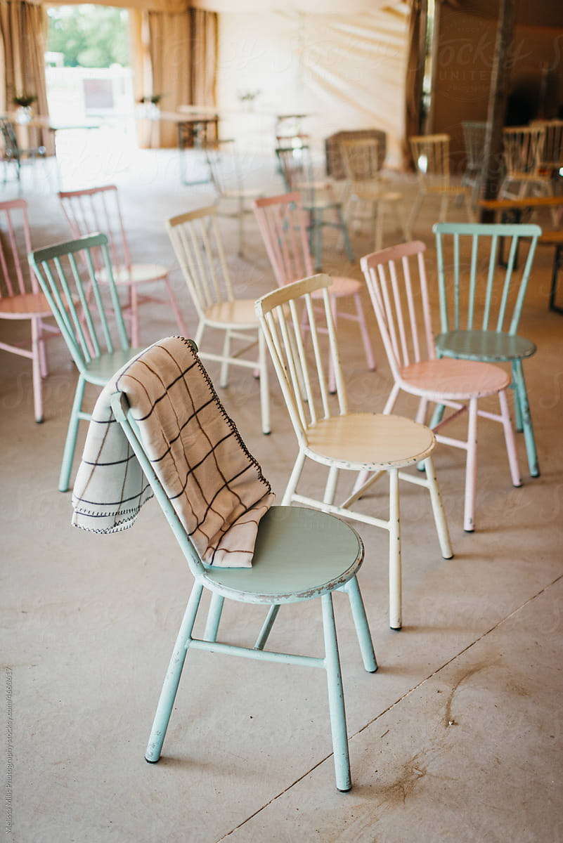 Pastel chairs lined up in a tent