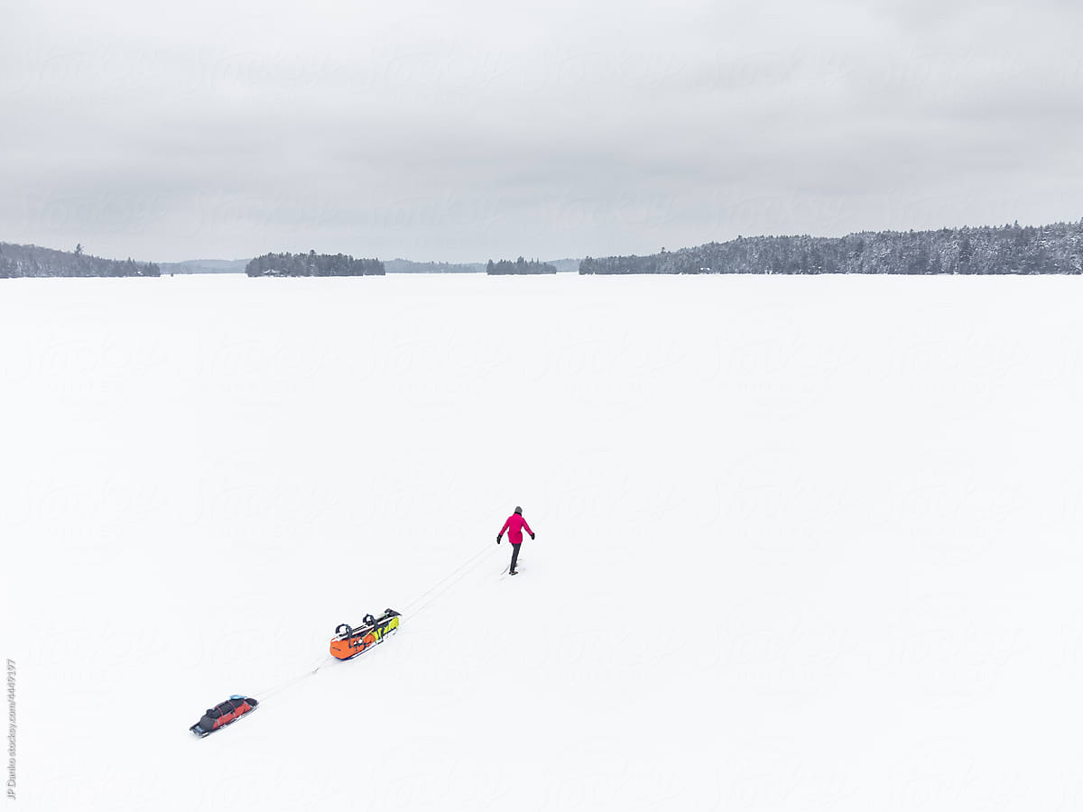 Snowshoeing Trek with Winter Camping Gear on Frozen Lake