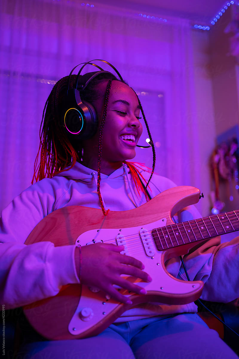 Happy Teen Girl Playing An Electric Guitar At Home.
