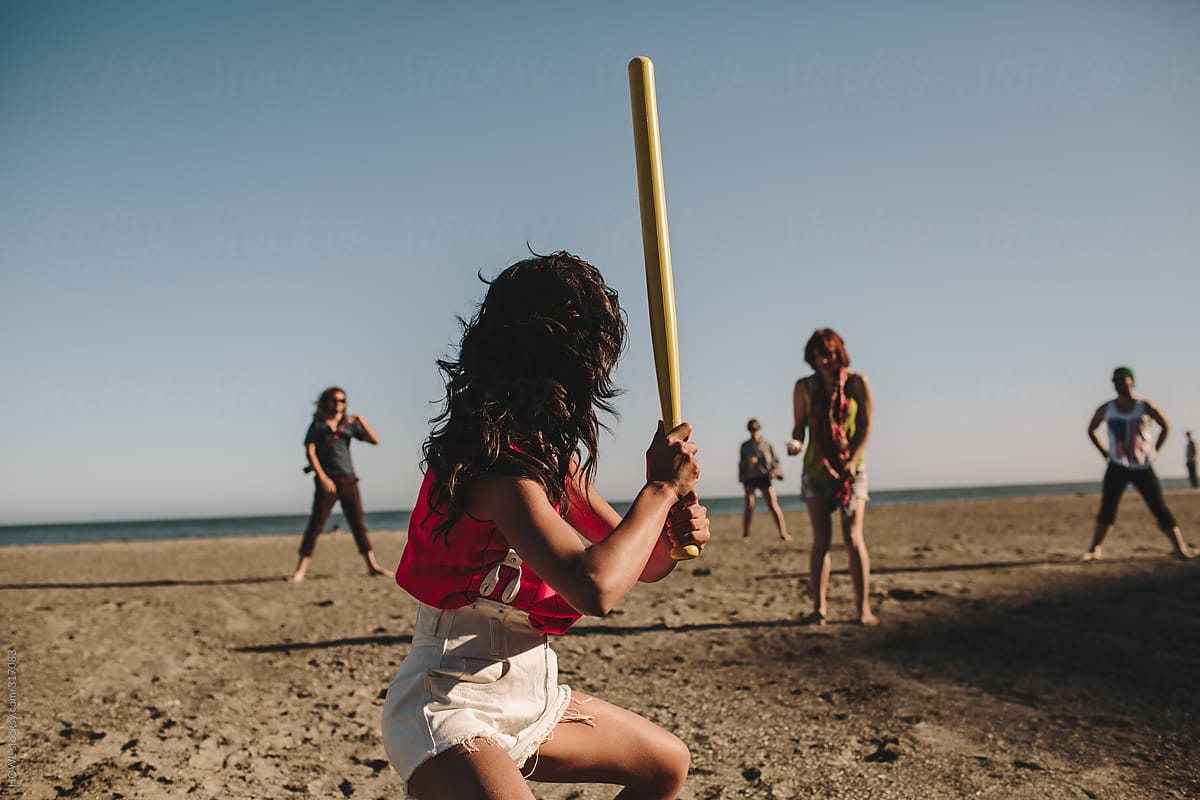 Young group playing softball on the beach in California