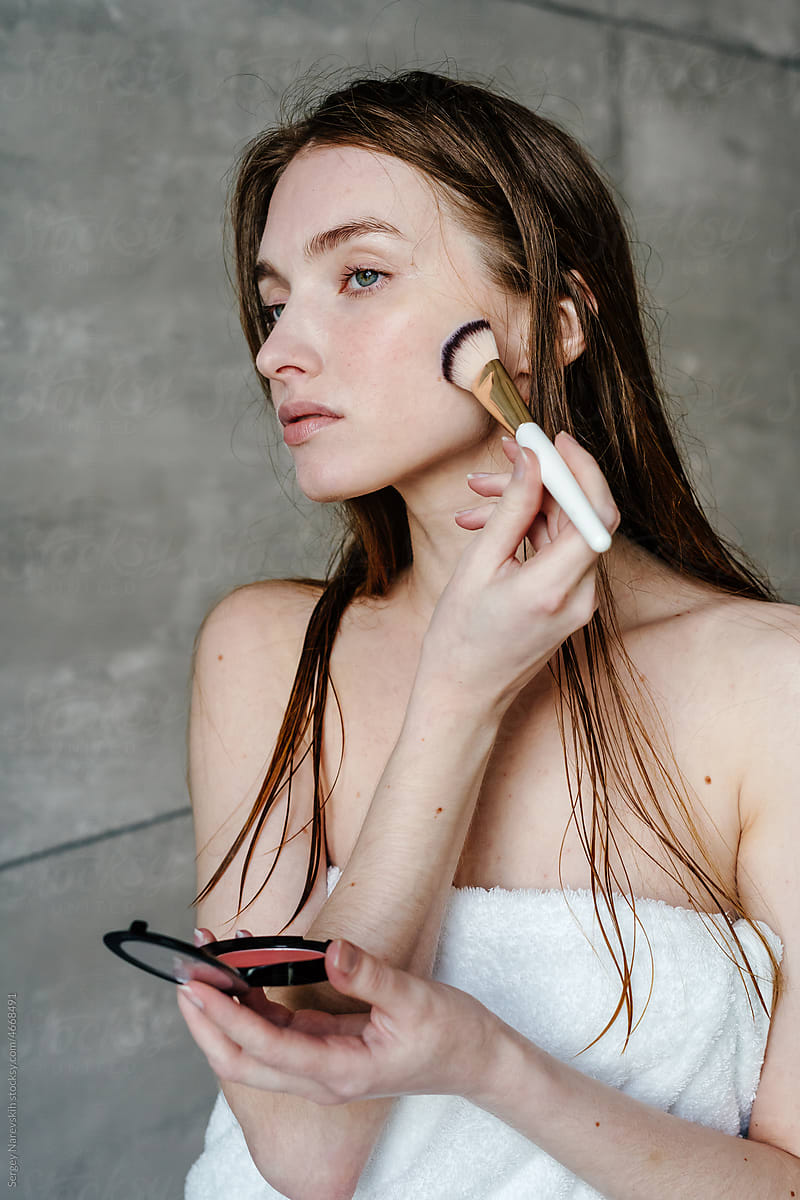 Feminine lady applying makeup after shower