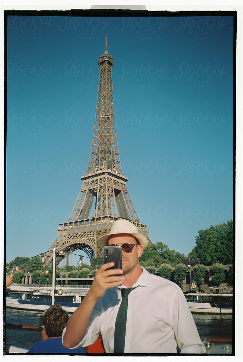 Man with tie taking selfie with Eiffel Tower