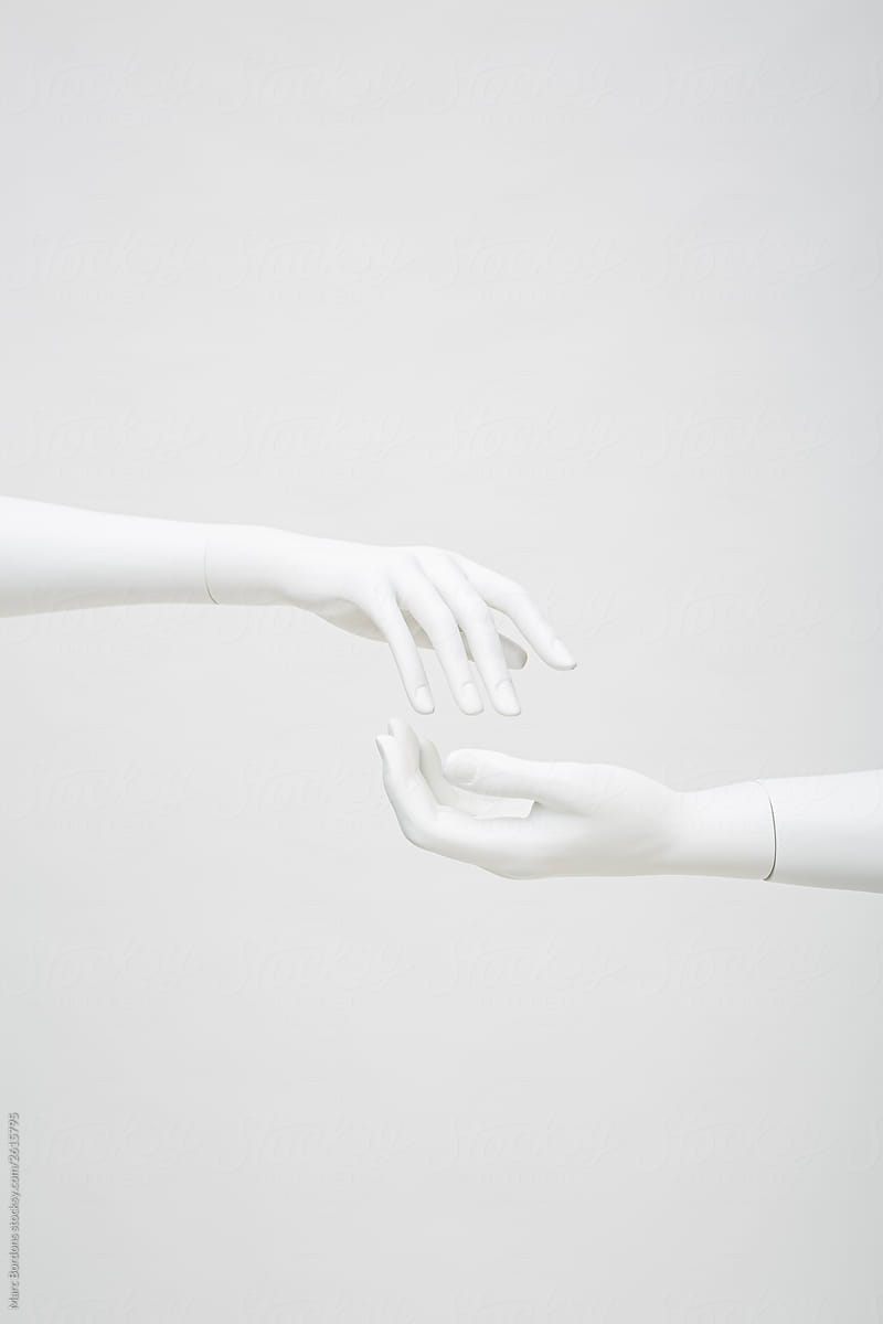 cropped picture of two hands reaching out. Both are white mannequin hands
