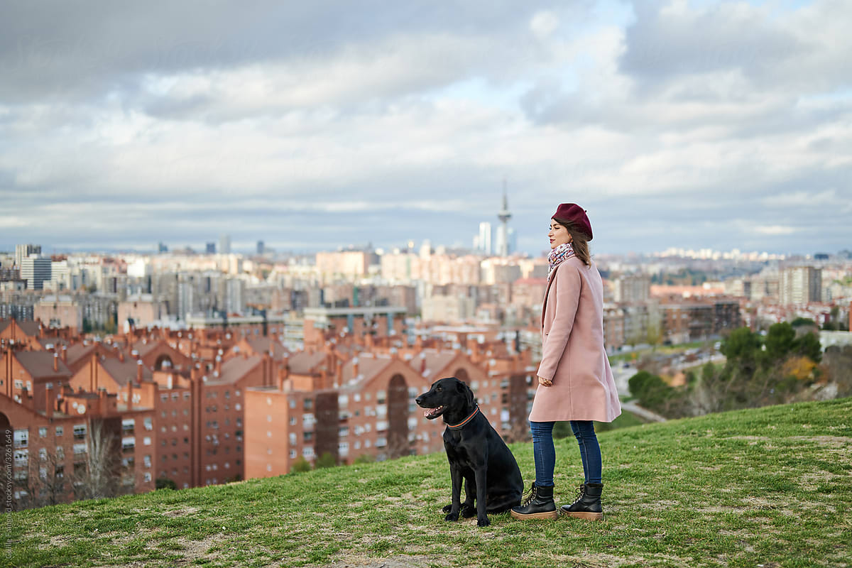 Elegant woman and dog admiring town