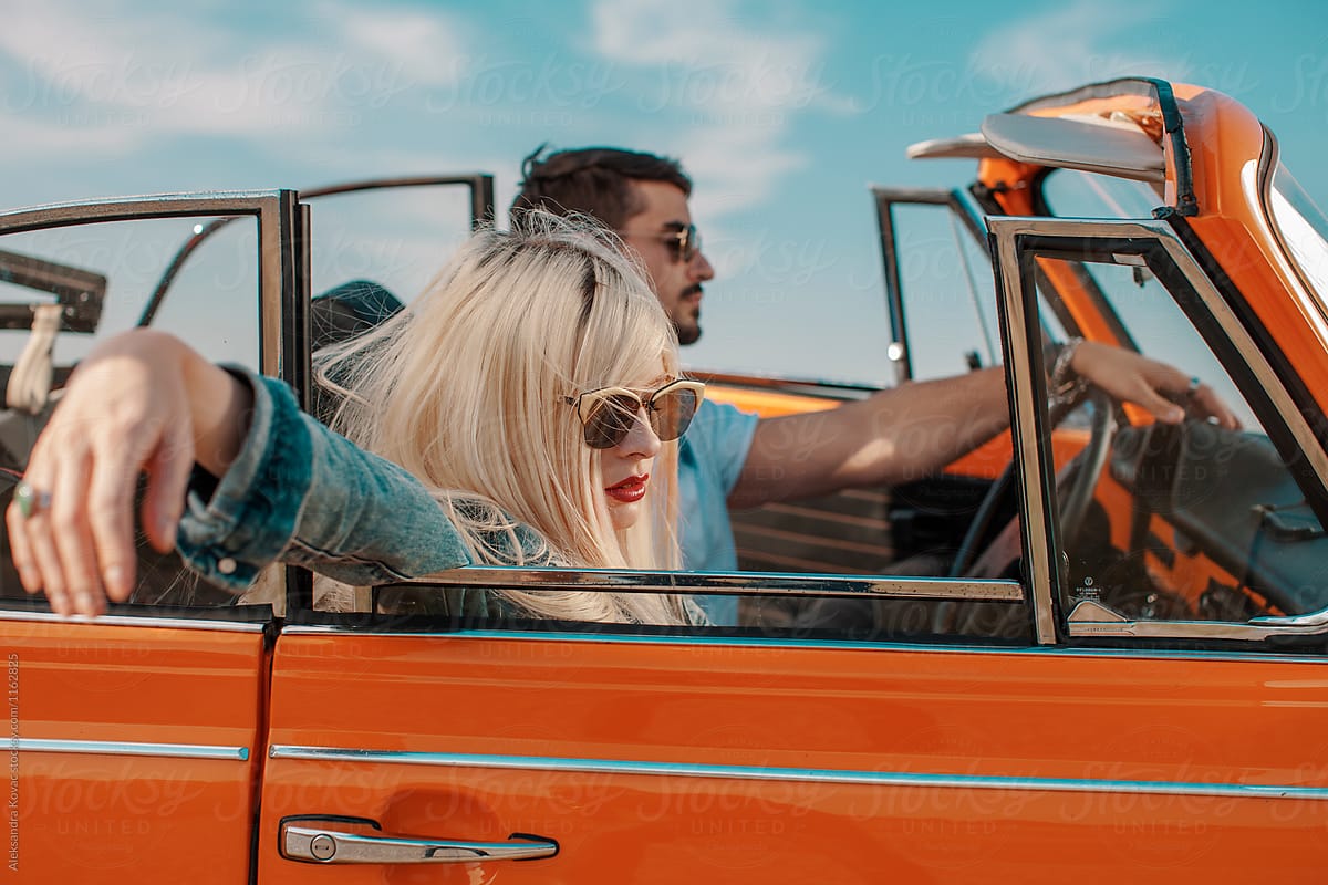 Beautiful couple in retro car travel on a road trip.