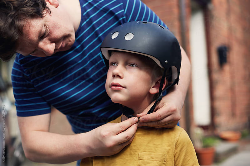 Father putting on sons safety helmet