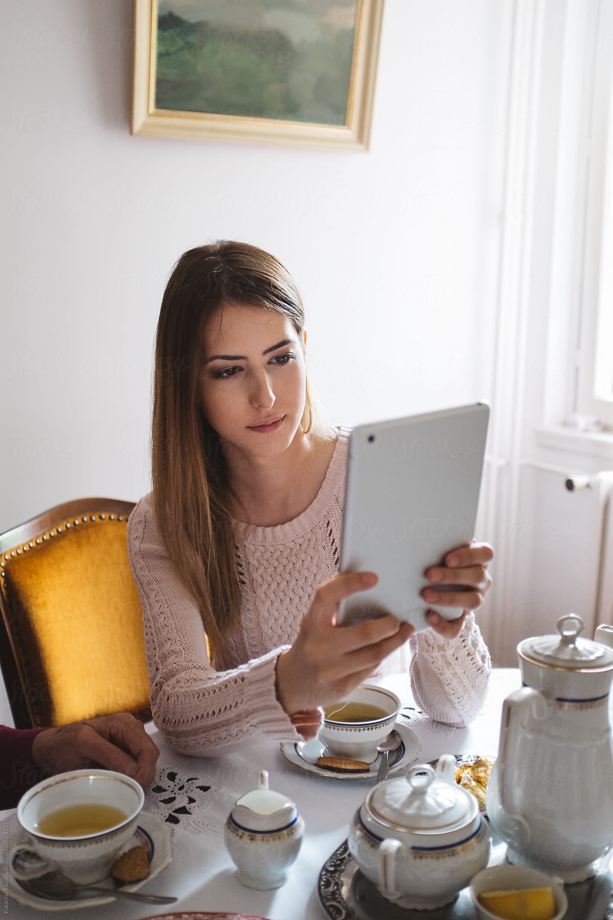 Woman Using Tablet Computer While Having Tea Time